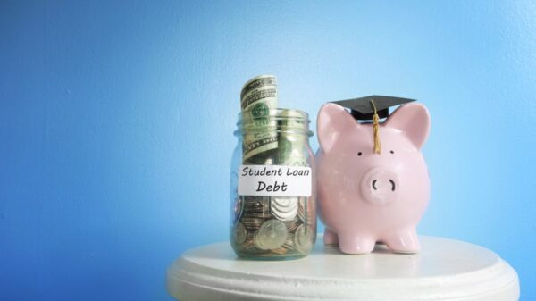 piggy bank in a graduate cap next to a jar of money.