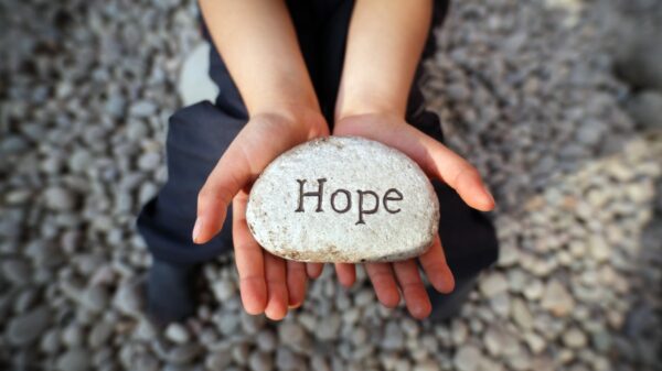 holding a rock that says hope.