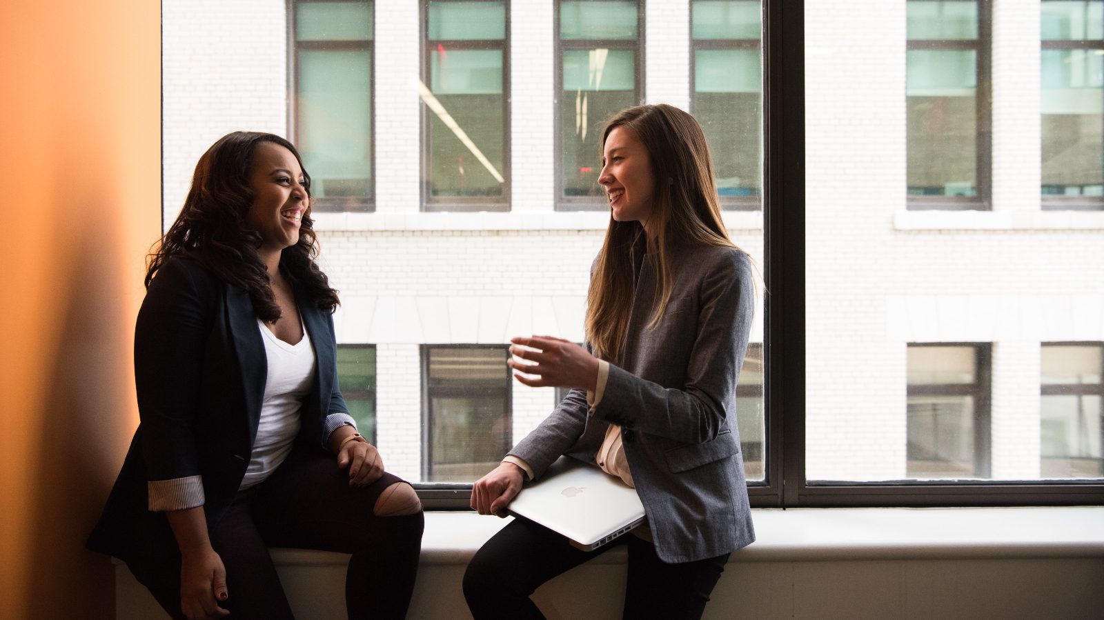 black and white women talking in an office.
