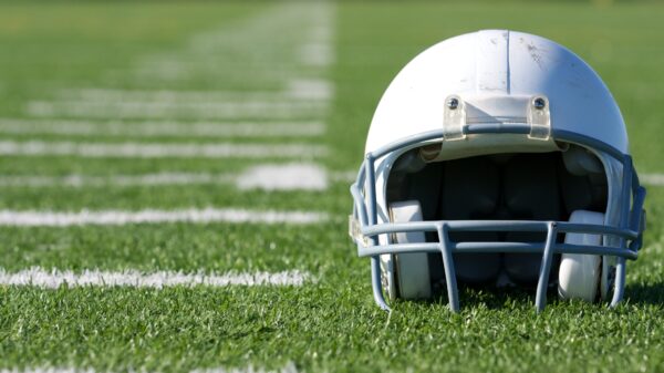 White football helmet on green football field.