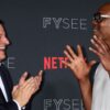 Dave Chappelle and Ted Sarandos laughing at Netflix red carpet.