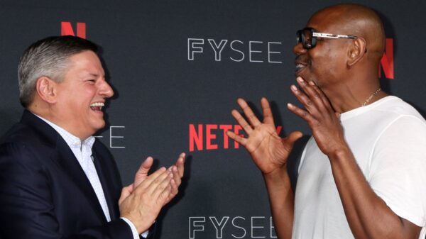 Dave Chappelle and Ted Sarandos laughing at Netflix red carpet.