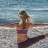girl doing yoga on the beach.