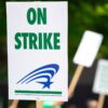 white sign with 'on strike' written in green ink.