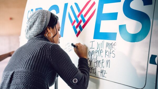 Woman writing on a Giving Tuesday poster.