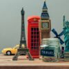 travel jar surrounded by figurines of monuments from around the world.