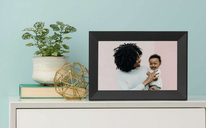 smart frame on a table showing a smiling mother and son.