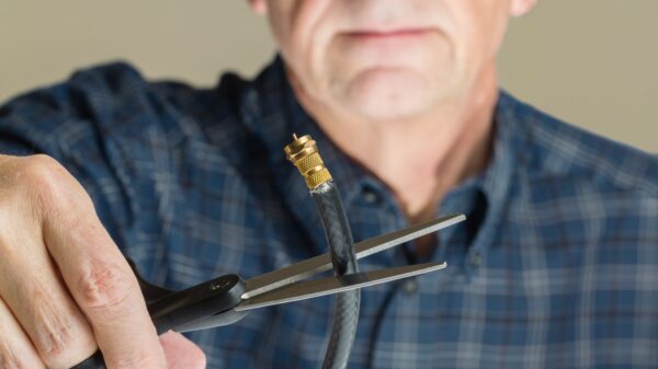 Man cutting a cable cord with scissors.