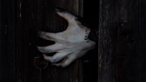A creepy hand coming out of a doorway.