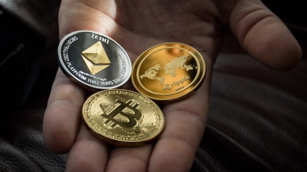 A hand holding physical representations of cryptocurrency.