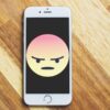An angry emoji displayed on an iphone.