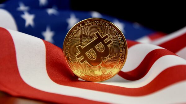 A golden Bitcoin in front of a US flag.