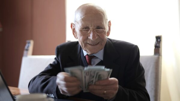 An old man in a suit counting cash.