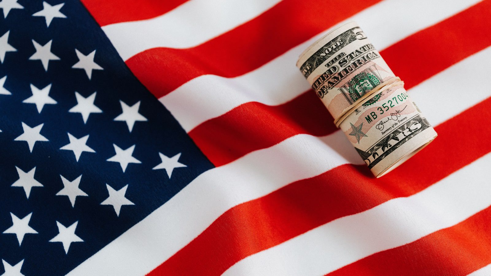 A roll of cash on an American flag.