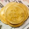 Golden Bitcoins on top of cash.