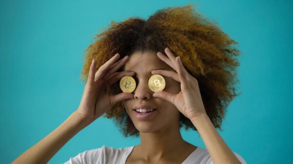 A woman holding to coins in front of her eyes.