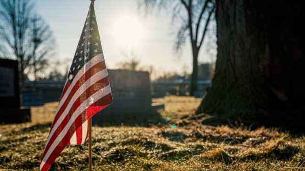 An American flag in front of a grave.