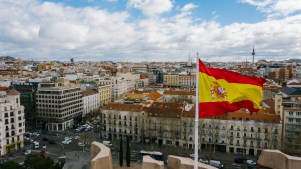 A Spanish flag in front of buildings.