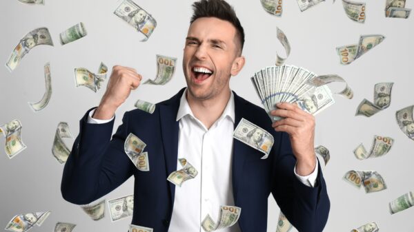A man excited as money rains around him.