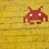 A Space Invader character on a brick wall.