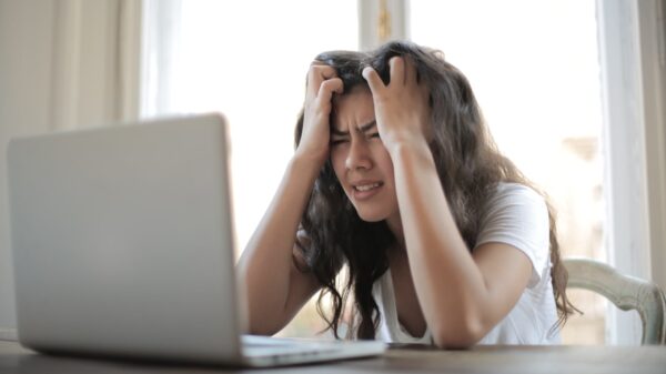 A stressed woman looking at her laptop.