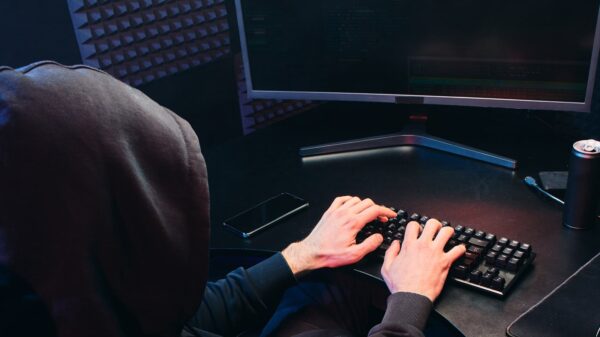 A hooded man using a computer