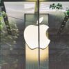 Apple logo behind a glass wall.
