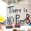 A person holding a sign that says "there is no planet B."