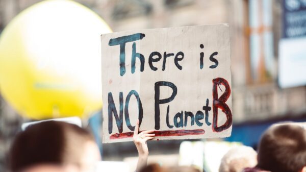 A person holding a sign that says "there is no planet B."