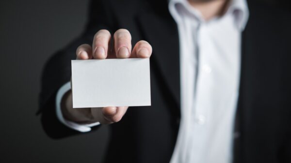 A man holding a blank business card.
