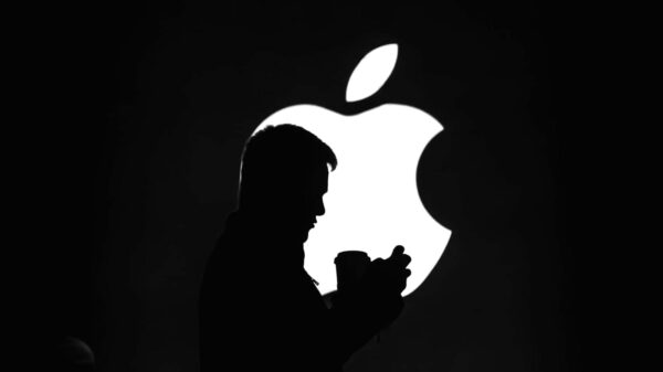 A silhouette of a man in front of an Apple logo.