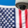 A security camera in front of an American flag.